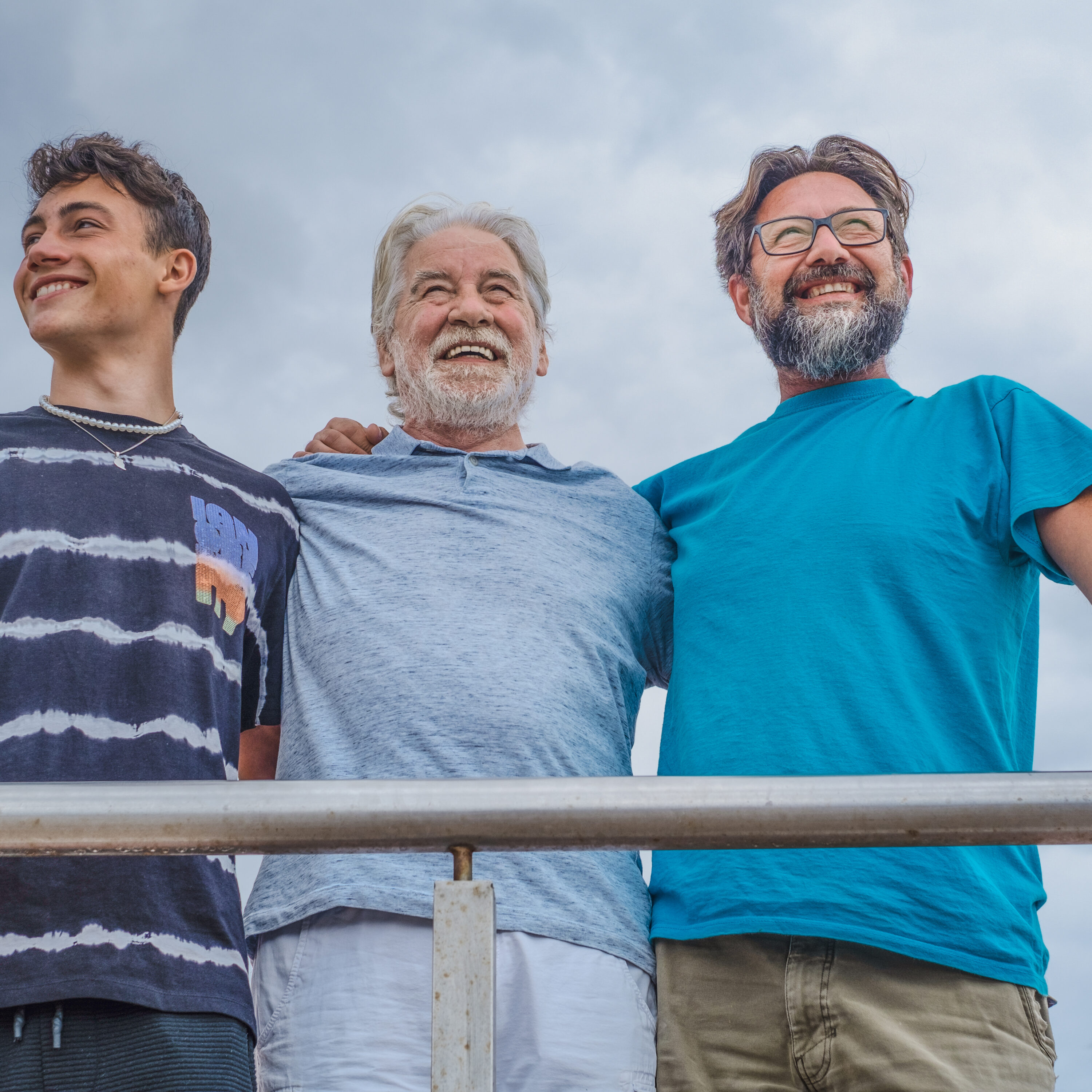Group Of Three Generation Family Hugging And Smiling Outdoors, G
